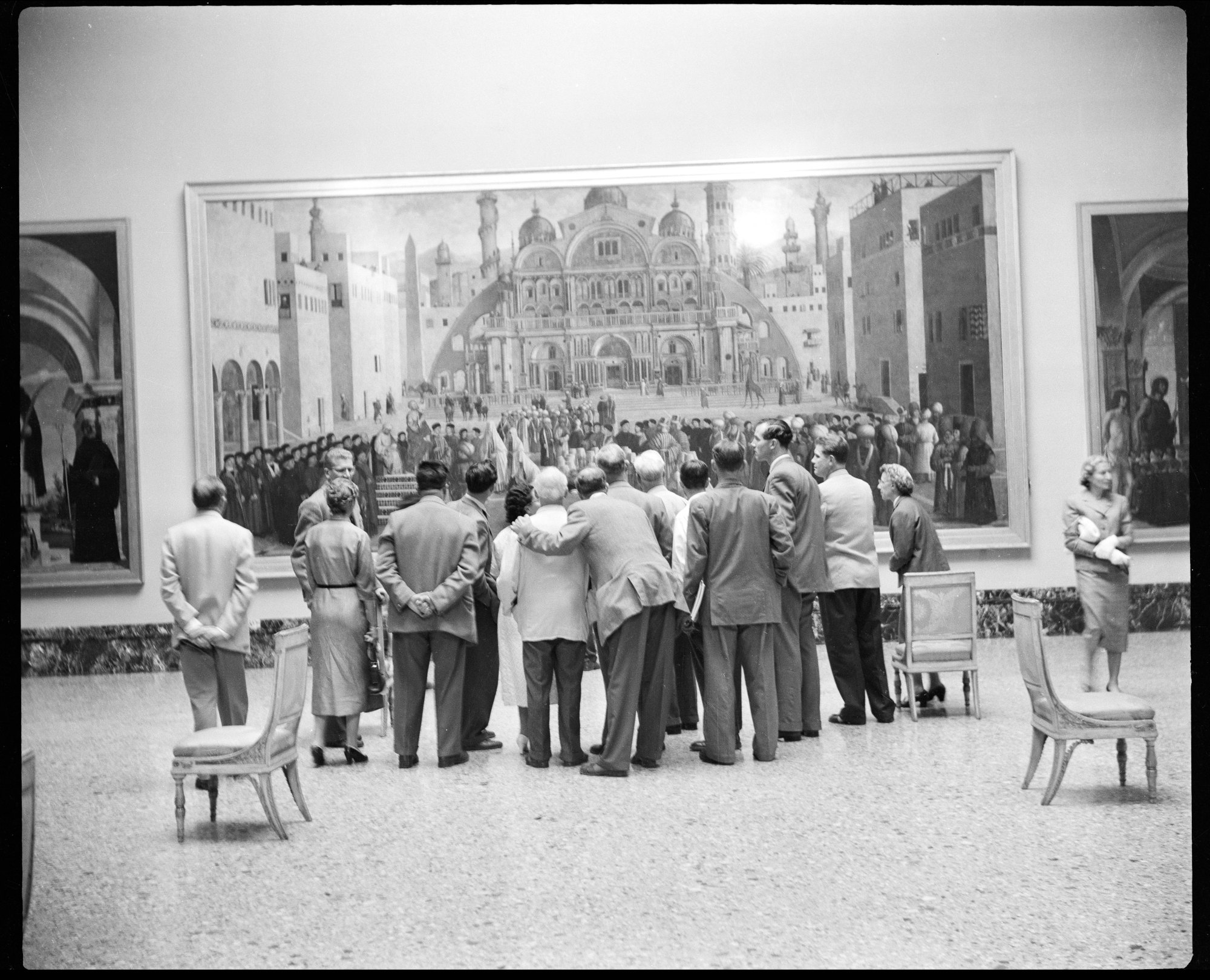 Un gruppo di turisti in una delle sale della Pinacoteca di Brera a Milano osserva il dipinto "Predica di San Marco ad Alessandria d'Egitto" di Gentile e Giovanni Bellini, 6 luglio 1956.  Fotografia di Angelo Novi – Publifoto. 