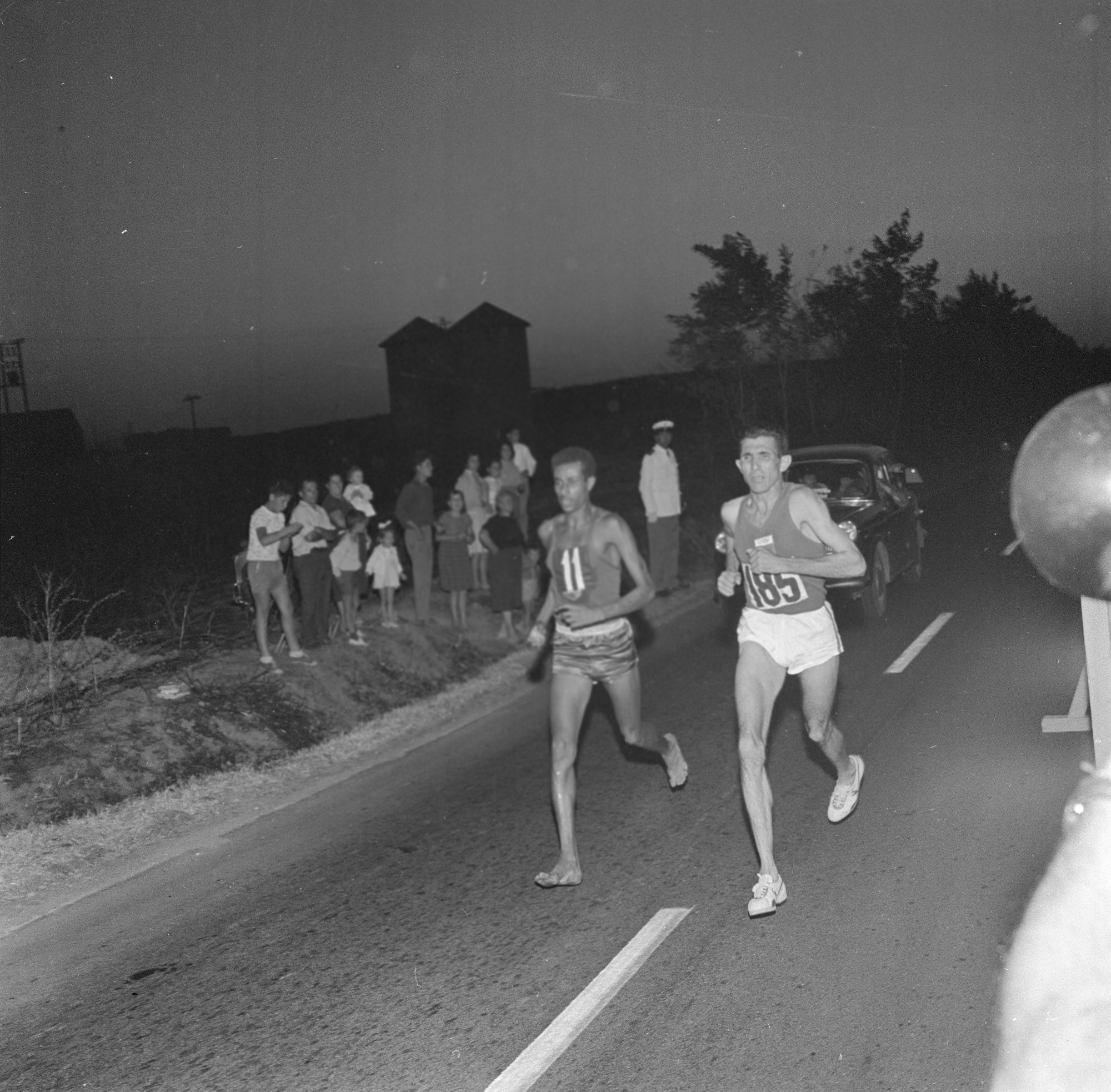 Abebe Bikila corre la maratona con la quale conquisterà la medaglia d'oro, XVII Olimpiade a Roma, 10 settembre 1960.  Fotografia di Publifoto. 