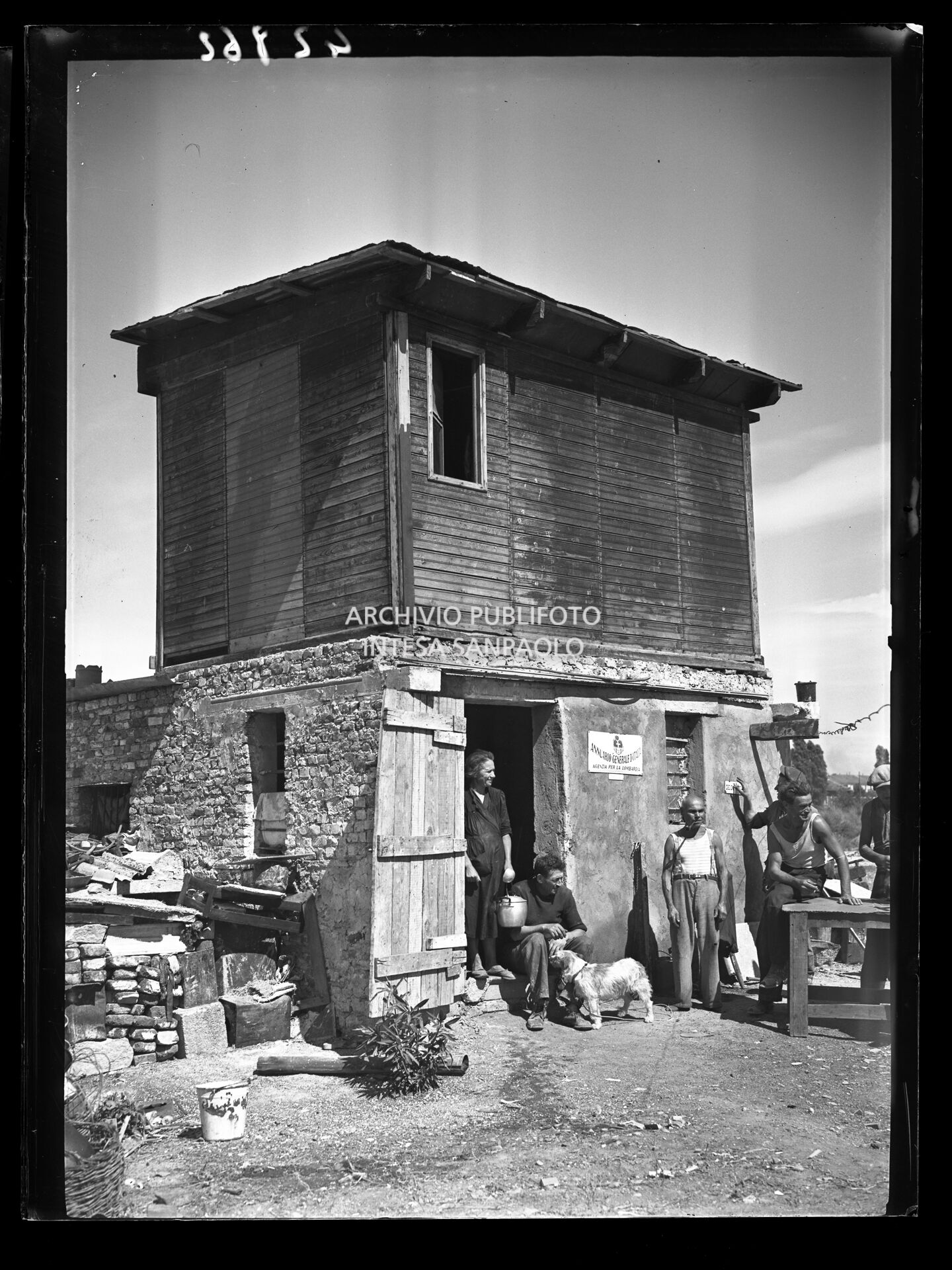 A group of people in front of a shack on the outskirts of Milan