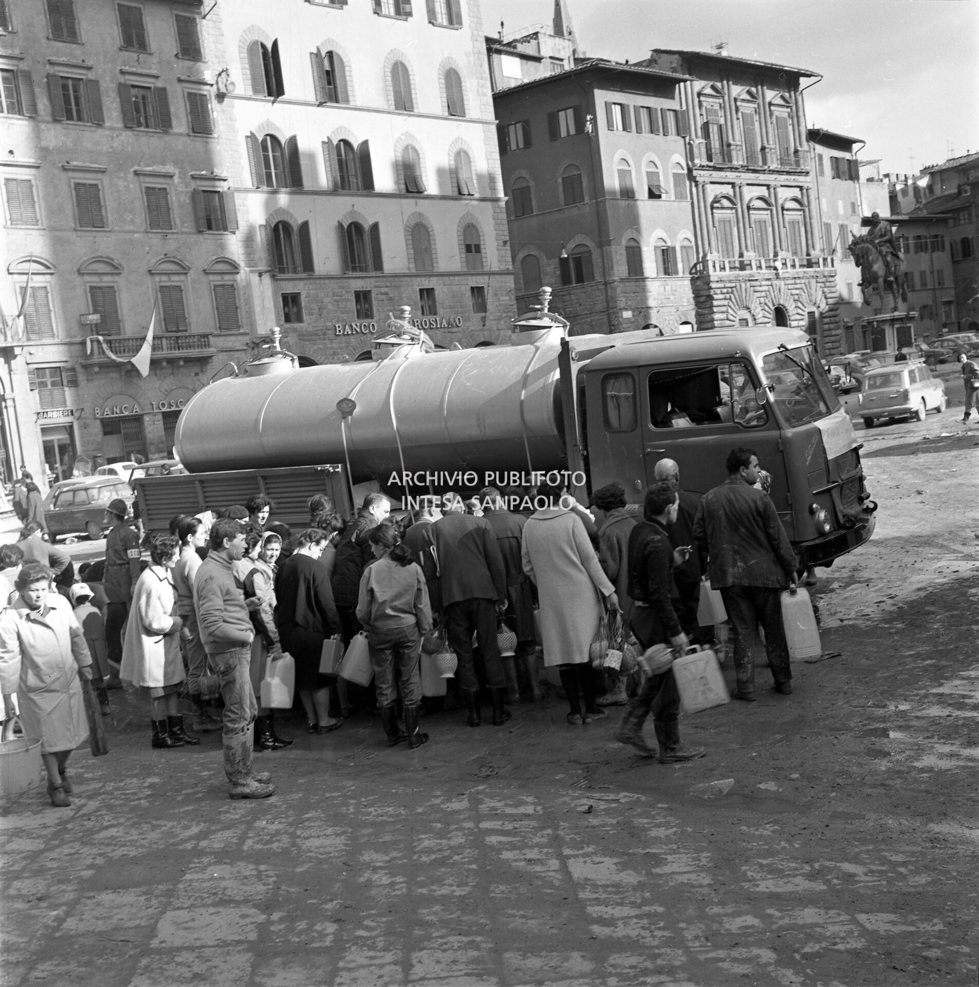 Distribuzione di acqua potabile in piazza della Signoria a Firenze dopo lo straripamento del fiume Arno