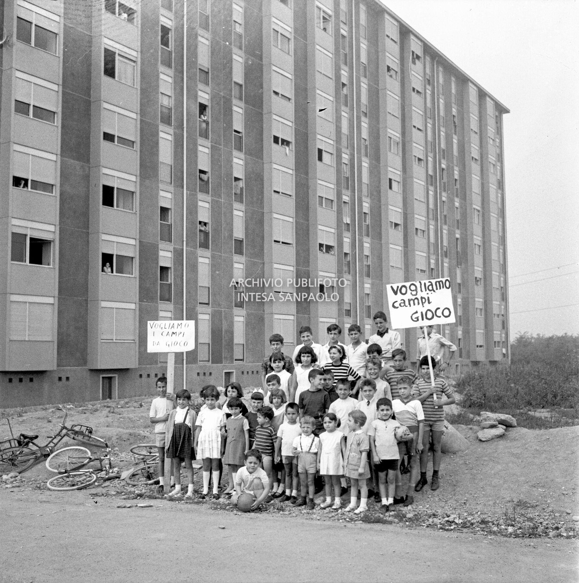 Un gruppo di bambini con cartello di denuncia per la mancanza di spazi gioco nel nuovo quartiere Gallaratese