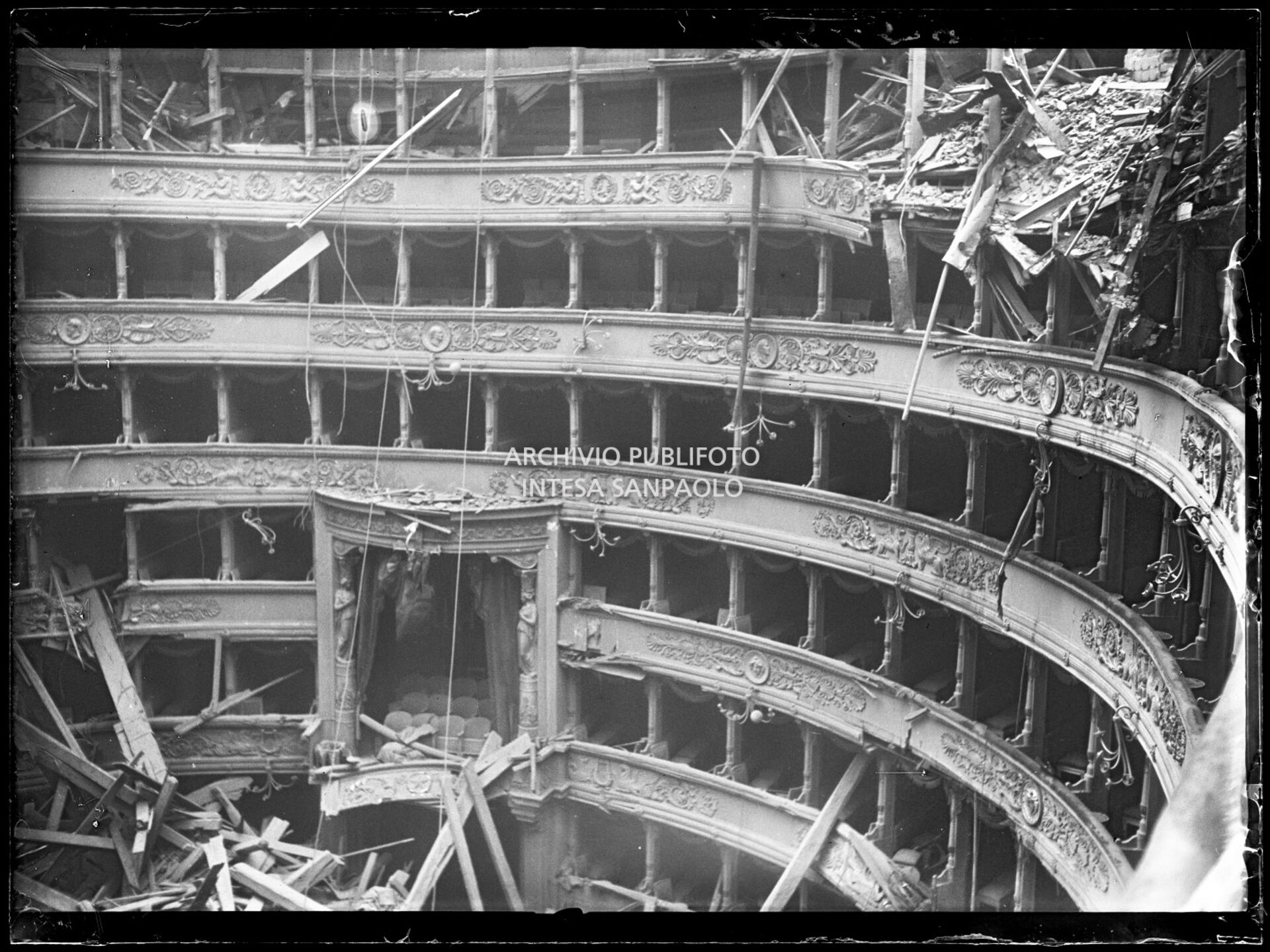 Palchi del Teatro alla Scala di Milano, tra cui il palco reale, gravemente danneggiati dopo i bombardamenti che hanno causato il crollo del tetto e della volta centinata sottostante distruggendo in parte il quinto e sesto ordine di gallerie e danneggiando il proscenio e la platea.