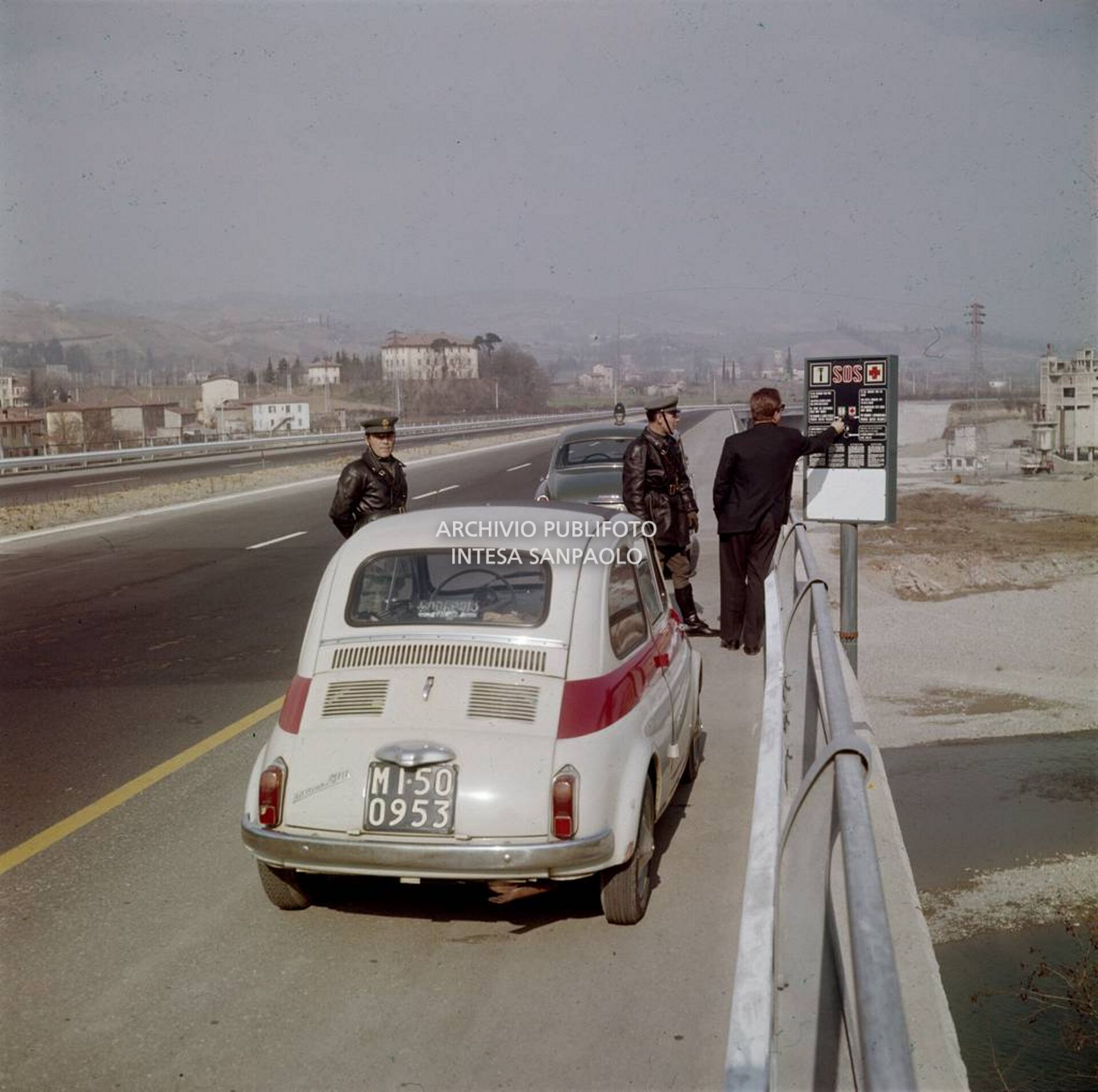 Un automobilista e due poliziotti davanti ad una colonnina SOS posta in autostrada