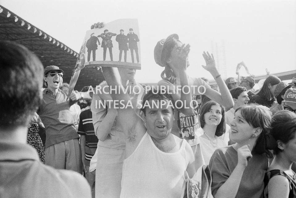 Fan scatenati al concerto pomeridiano dei Beatles al Vigorelli di Milano: un uomo mostra una fotografia della band, 24 june 1965, Cossu, Sergio, Pavone, Eugenio, Publifoto