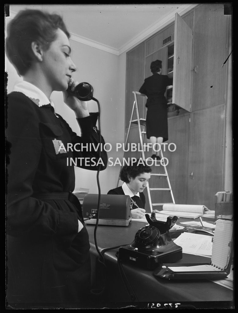 Impiegate al lavoro nei nuovi uffici della Omnia Pubblicità; in primo piano un'impiegata al telefono, 10 december 1952, Publifoto
