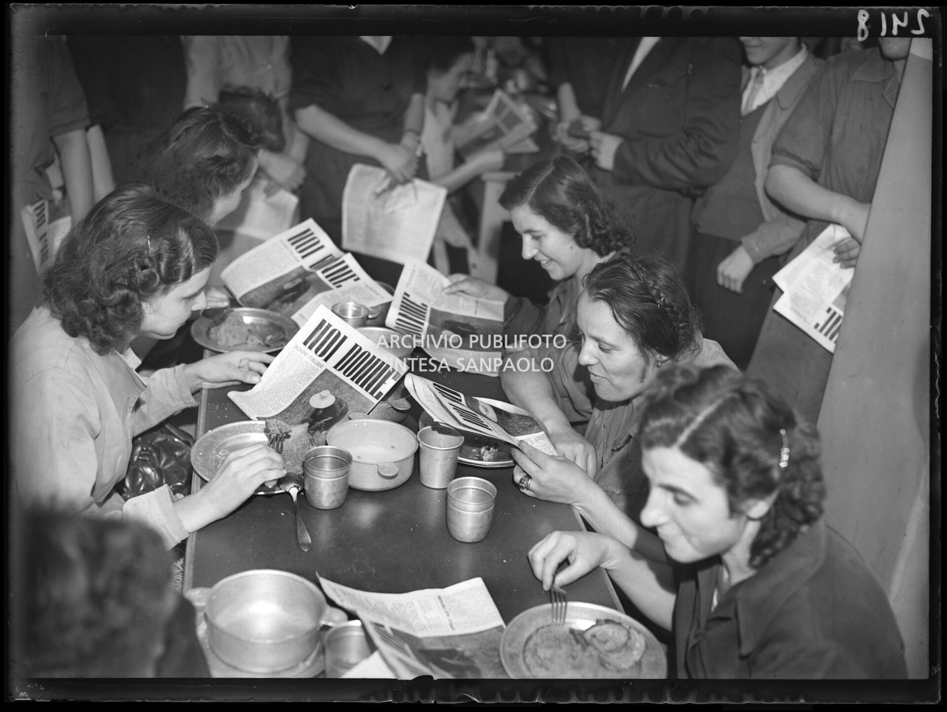 Un gruppo di donne, forse lavoratrici della fabbrica Pirelli, leggono una copia del giornale "Noi donne" in pausa pranzo