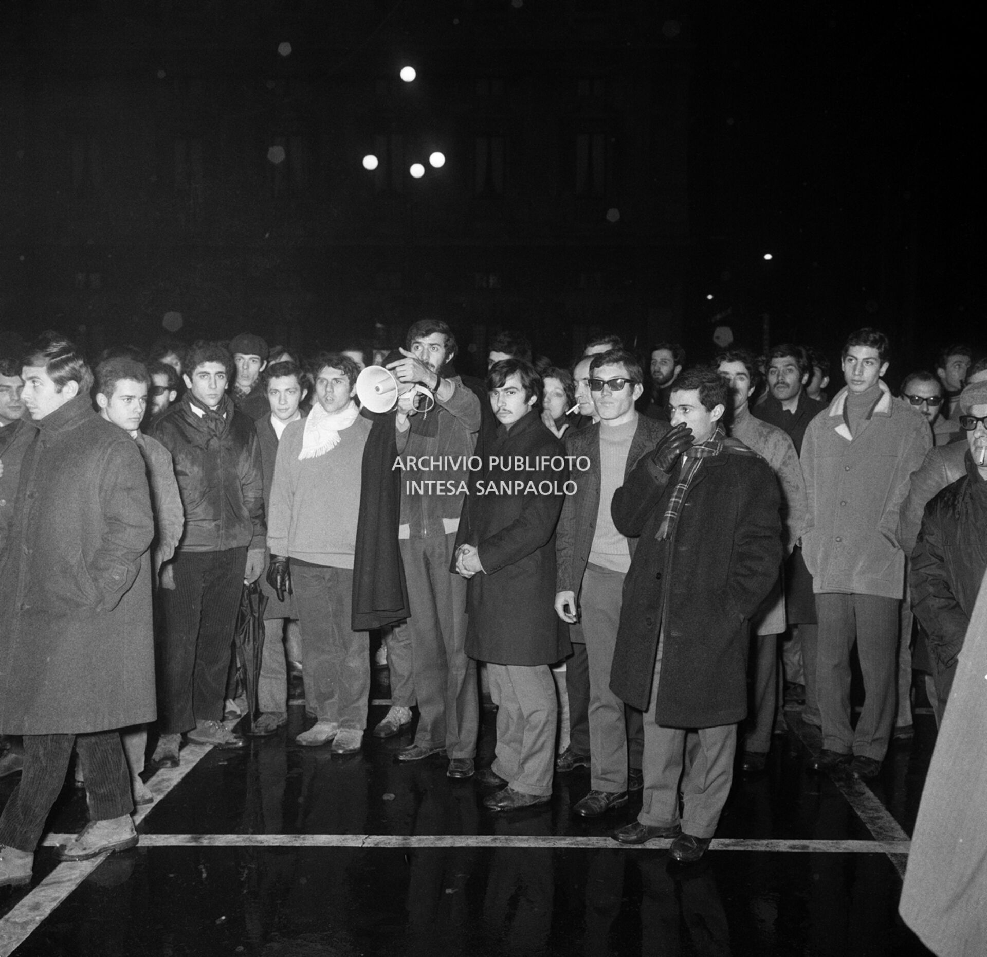 Un gruppo di giovani del Movimento studentesco, guidato da Mario Capanna (con il megafono), fuori dal Teatro alla Scala la sera dell'inaugurazione della stagione lirica 1968-1969