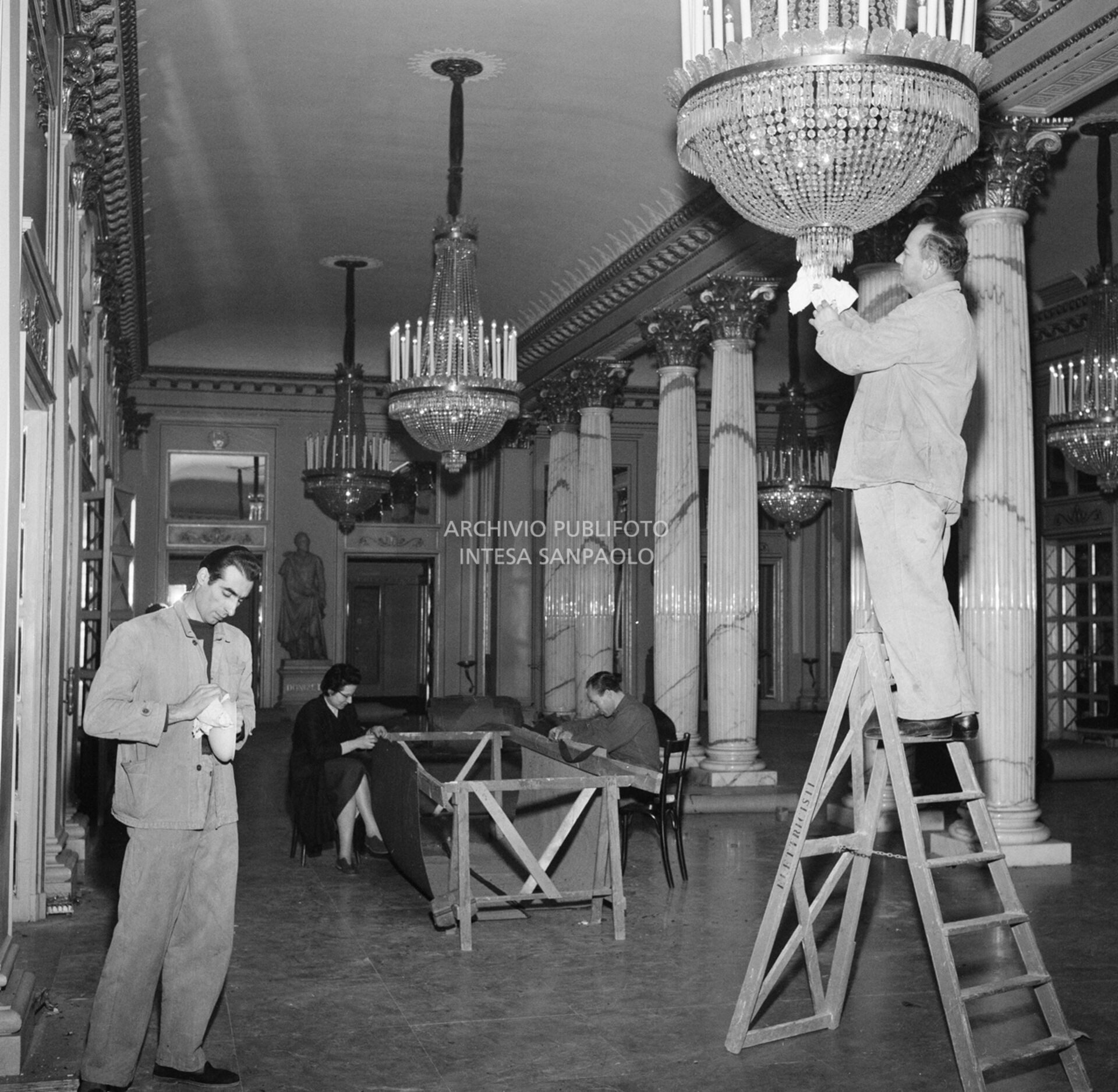 Addetti alle pulizie, nel foyer del Teatro alla Scala, lavorano in vista dell'inaugurazione della stagione lirica 1957-1958