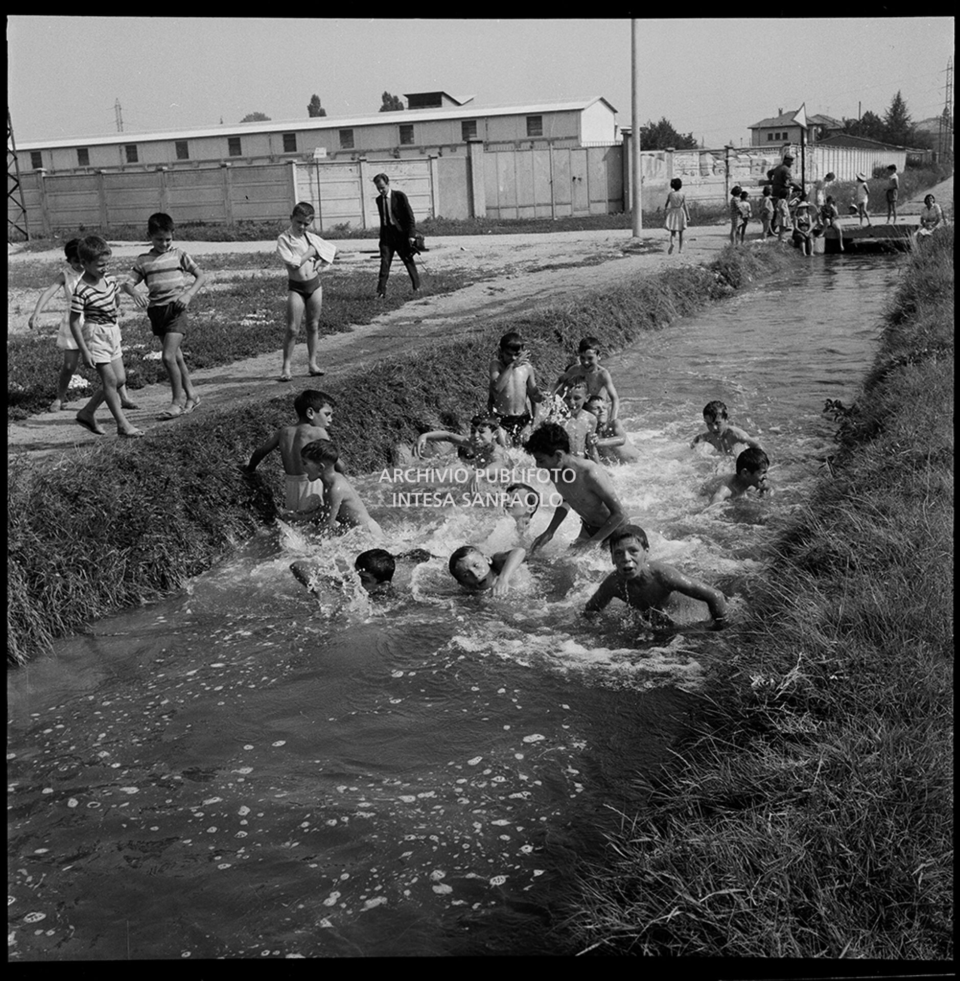 Children take a dip in a canal on the outskirts of Milan