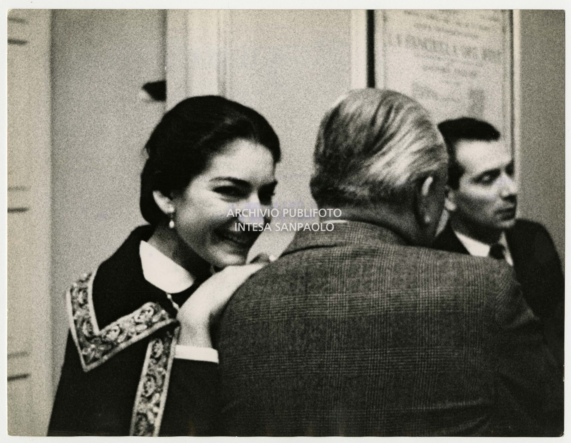 Maria Callas leans on the shoulder of her husband Meneghini backstage at La Scala
