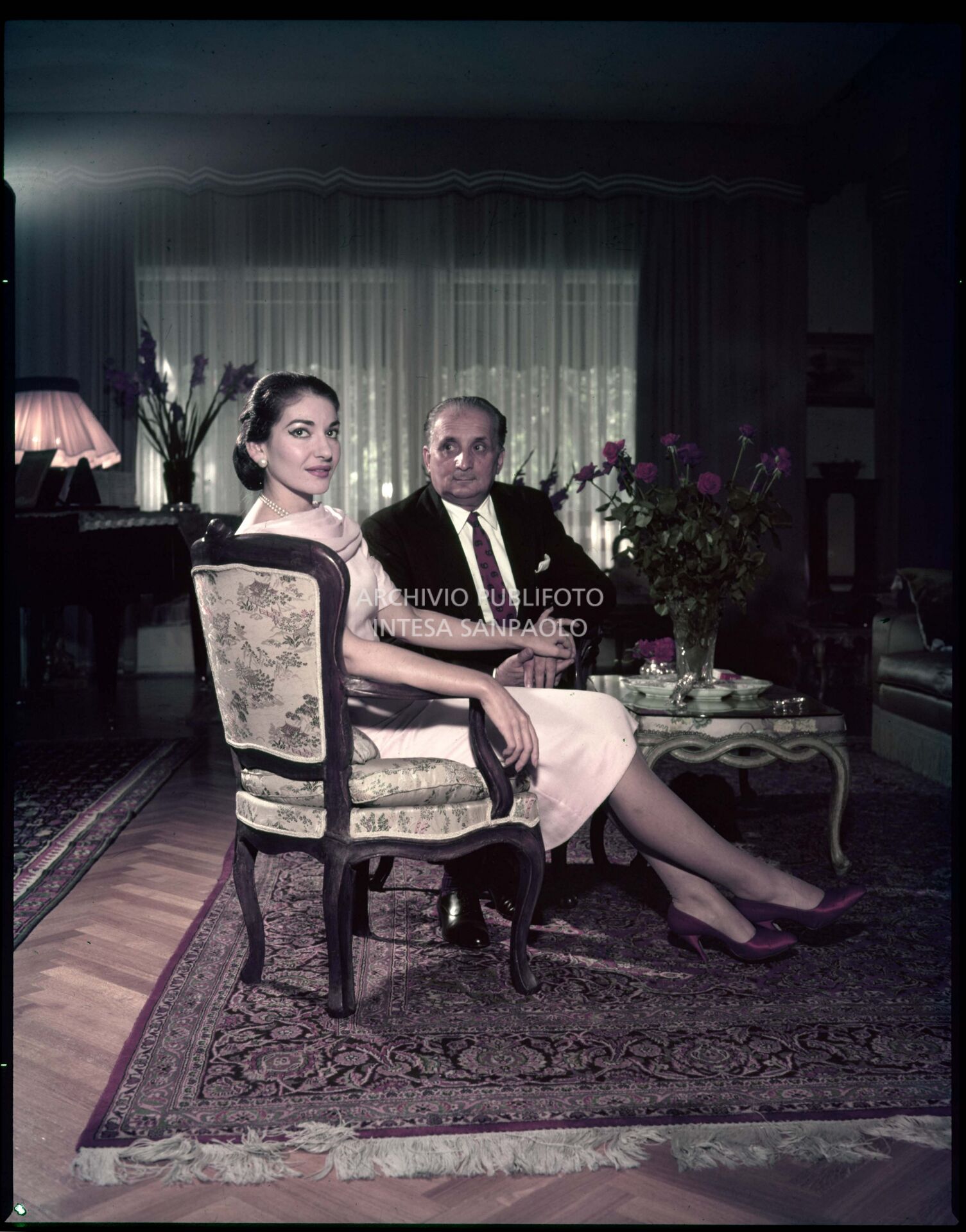 Maria Callas and her husband Giovanni Battista Meneghini posing in the living room