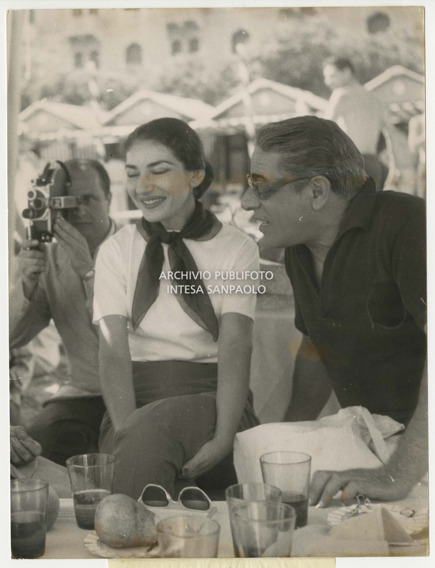 Maria Callas with Aristotele Onassis on the beach at the Excelsior during a reception hosted by Countess Natalia Volpi