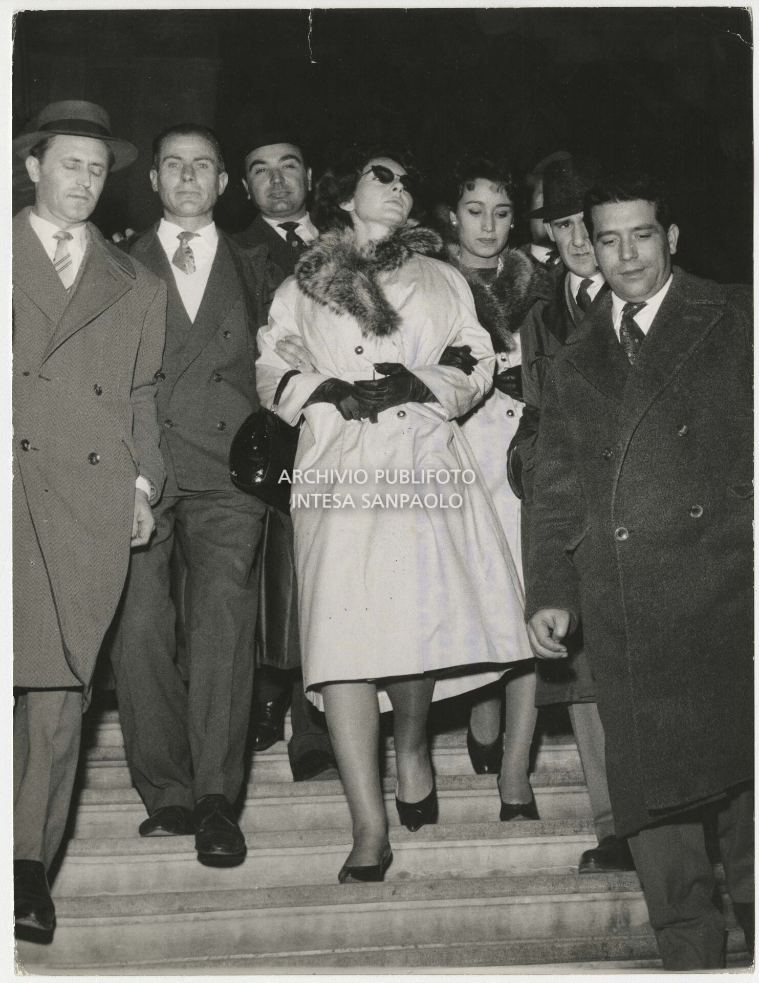 Maria Callas al Tribunale Civile di Brescia dove si è recata per la causa di separazione legale fra lei e il marito Giovanni Battista Meneghini; al suo braccio Giovanna Lomazzi
