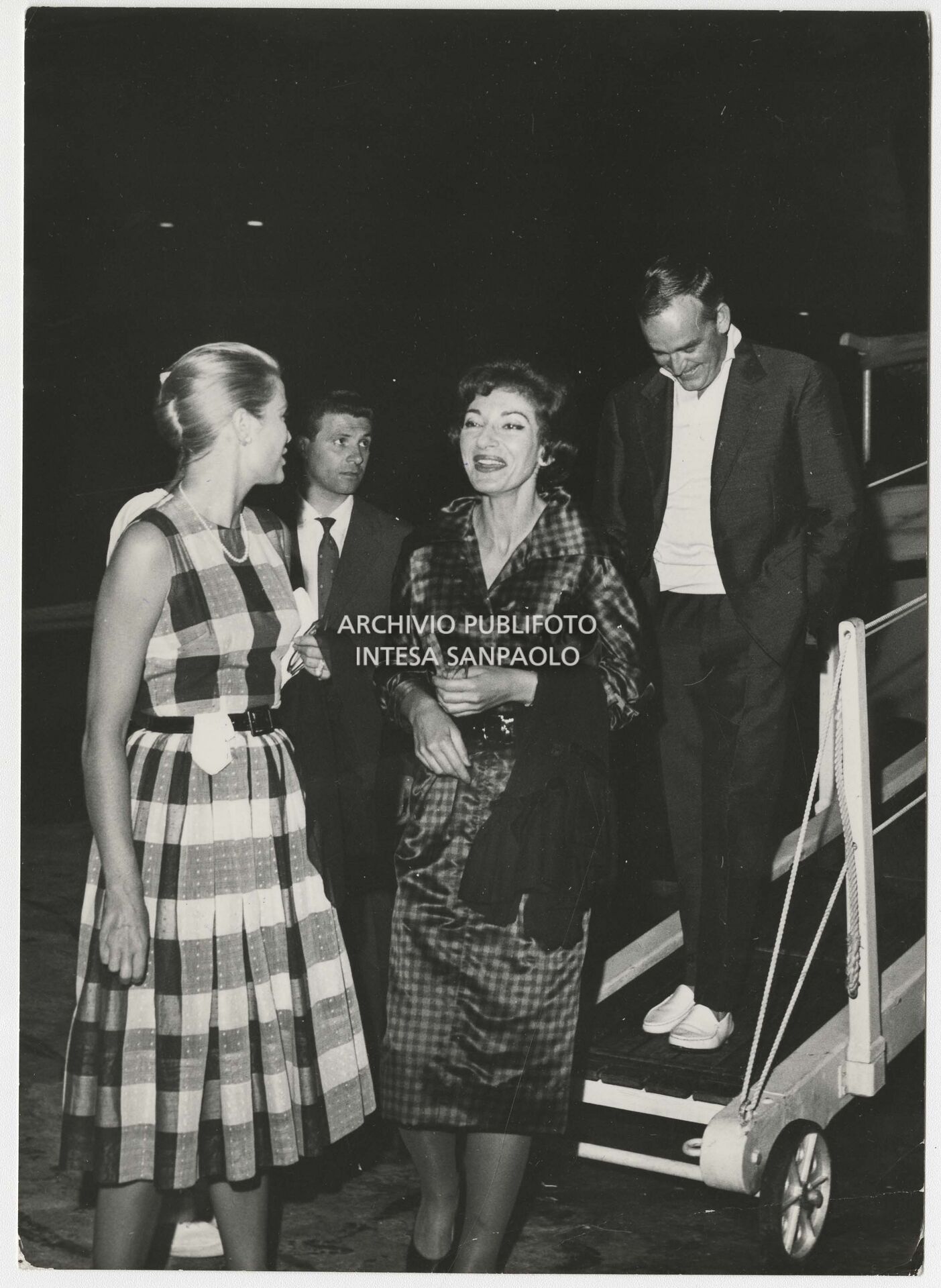 Maria Callas, Grace Kelly and Prince Rainier III of Monaco disembark from the royal yacht.