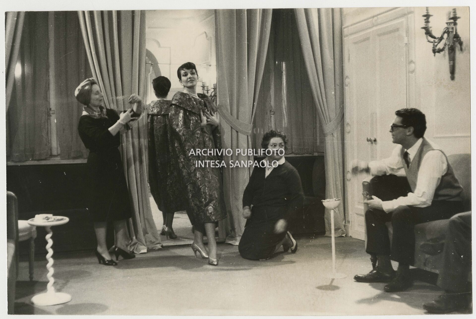 Maria Callas nell'atelier Biki prova un soprabito assistita dalla stilista Elvira Leonardi Bouyeure, detta Biki, e da una sarta