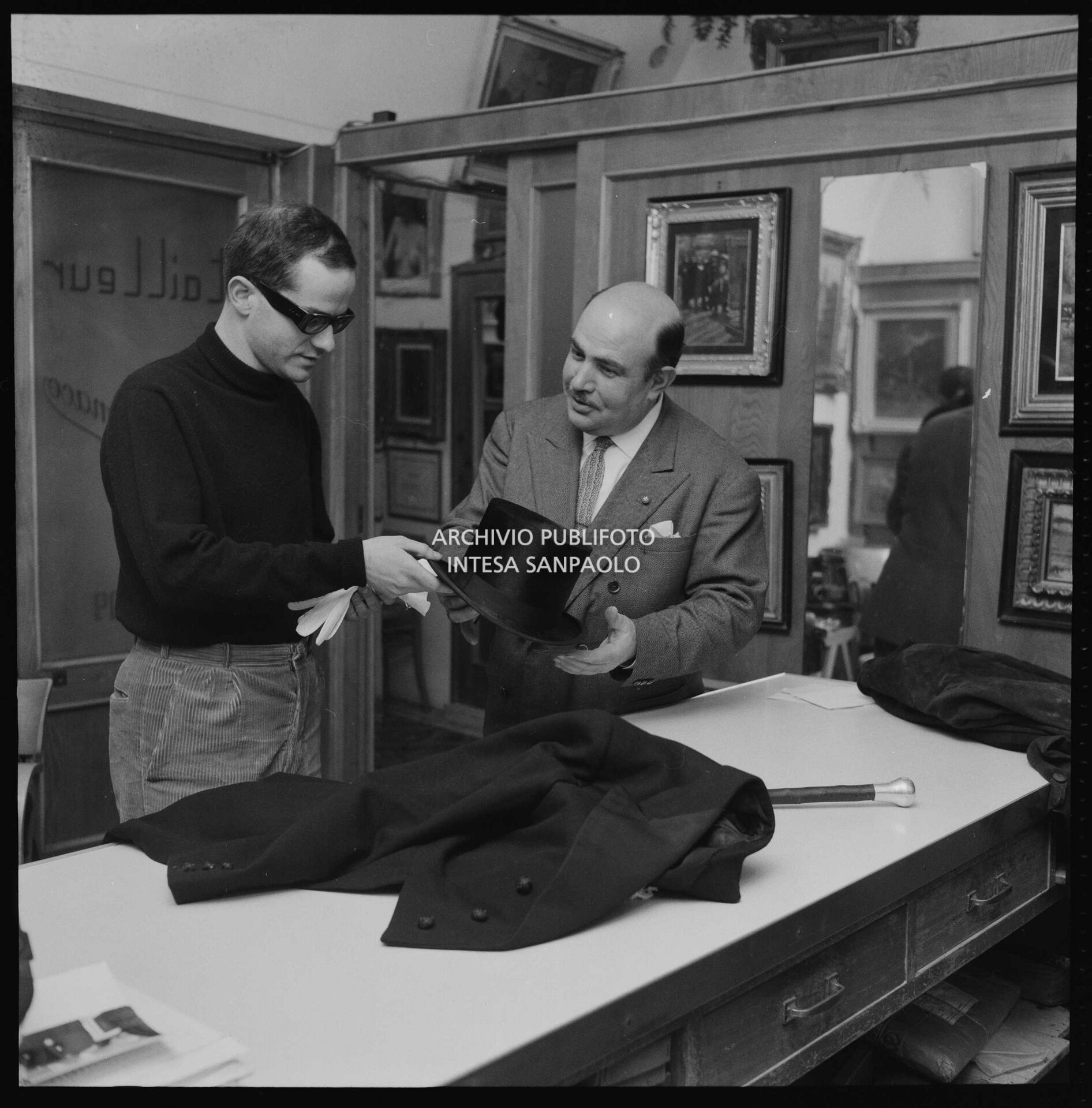 Gino Paoli sceglie frac e cilindro da indossare nei giorni dell'XI Festival di Sanremo in un atelier con l'insegna "tailleur".