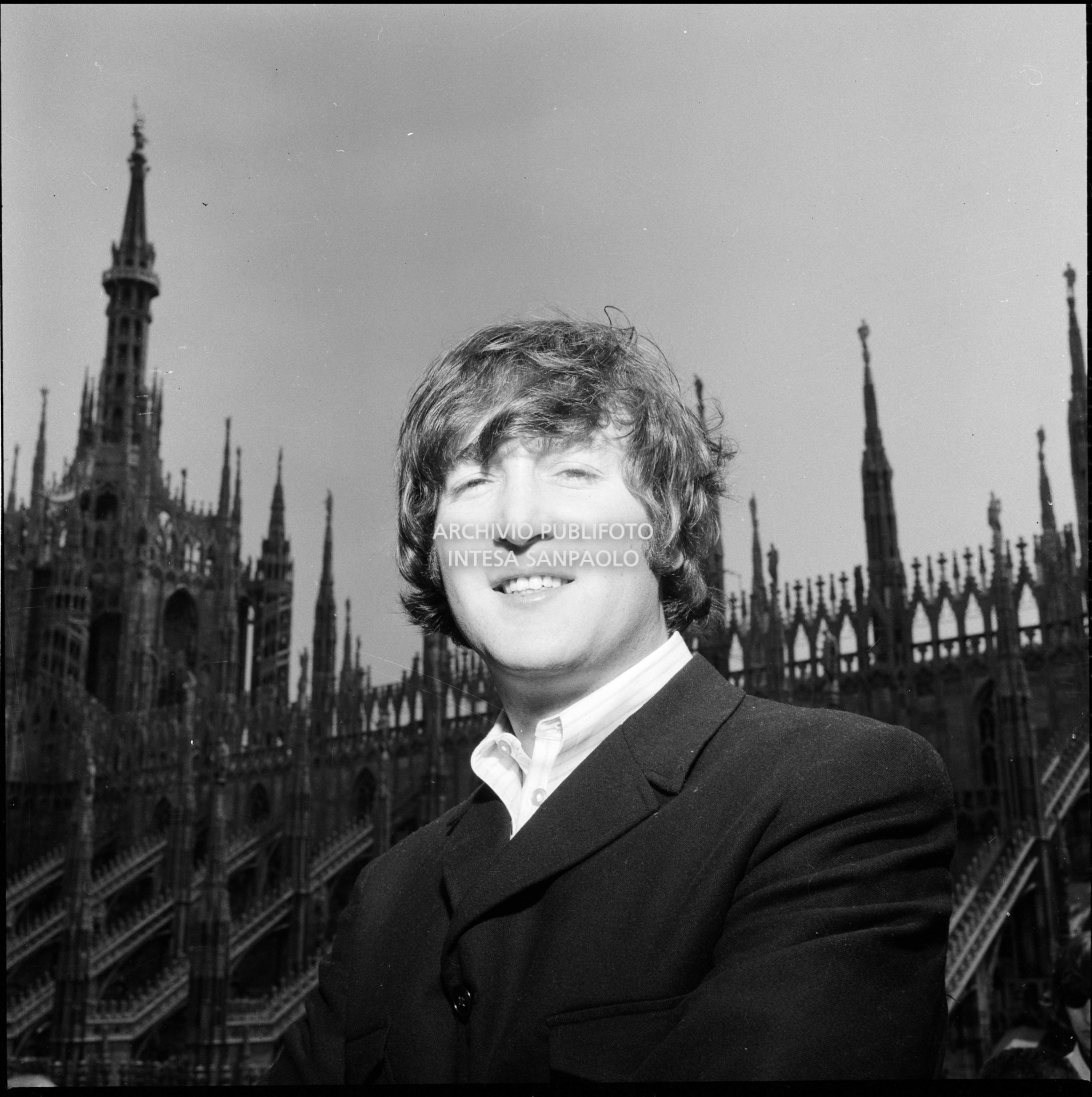 John Lennon ritratto sulla terrazza del Grand Hotel Duomo a Milano; sullo sfondo le guglie della cattedrale, 24 june 1965, Fumagalli, Carlo, Publifoto