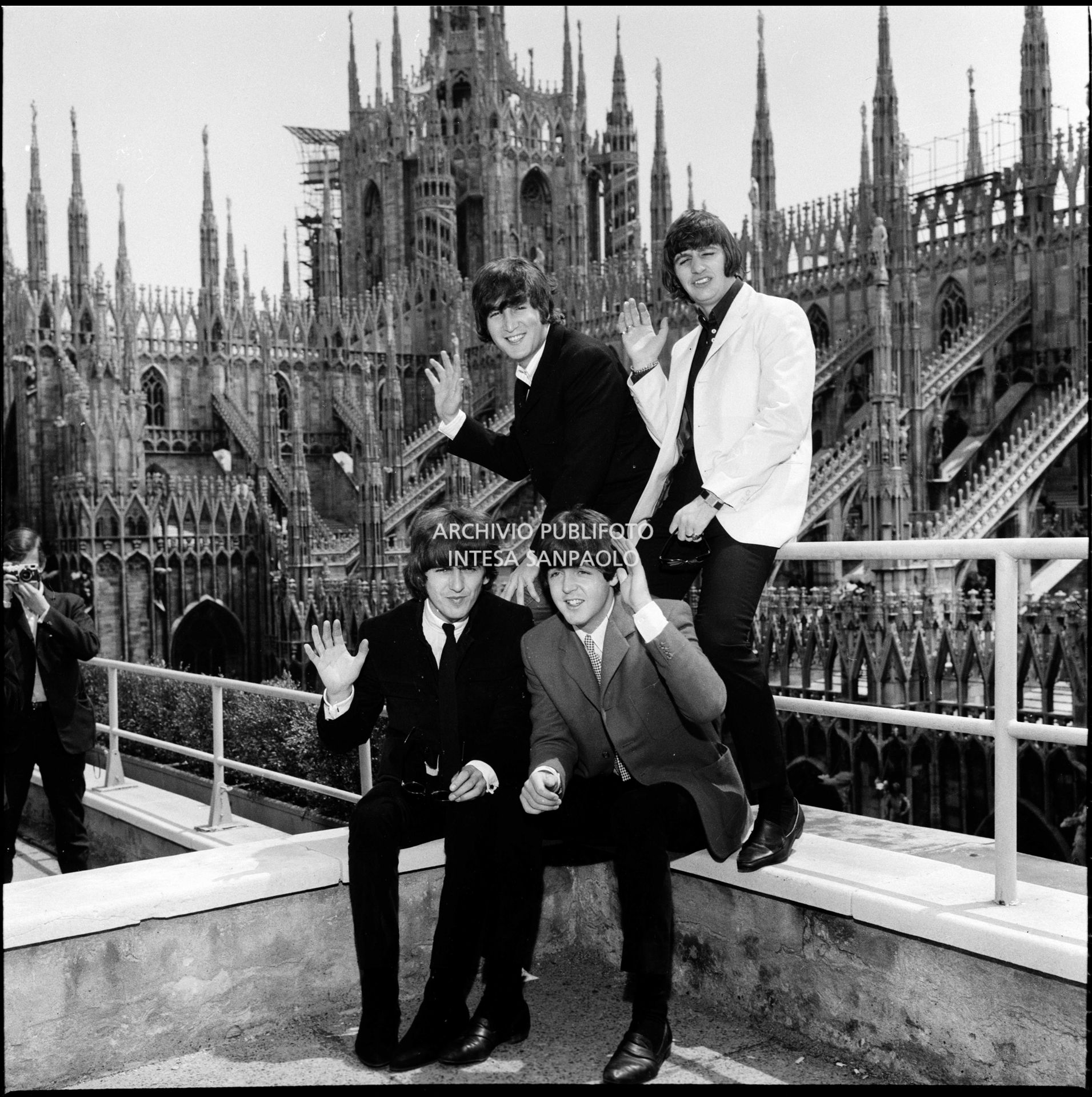I Beatles ritratti sulla terrazza del Grand Hotel Duomo a Milano; sullo sfondo le guglie della cattedrale