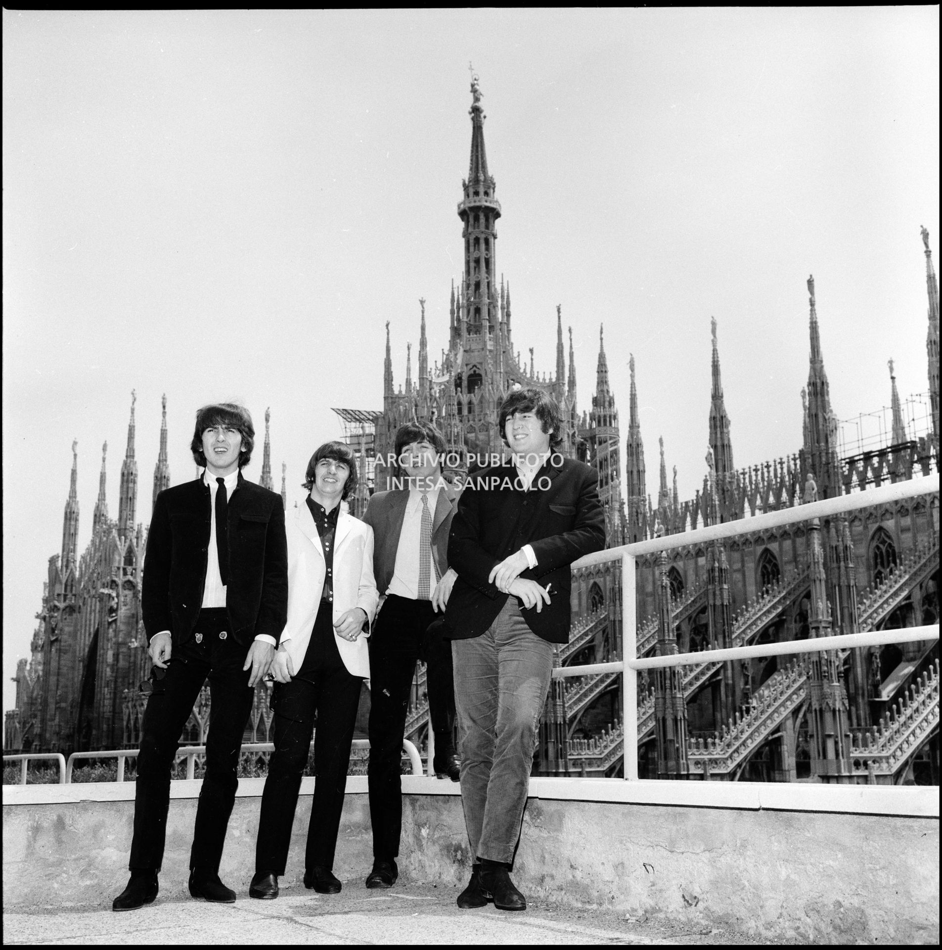 I Beatles ritratti sulla terrazza del Grand Hotel Duomo a Milano; sullo sfondo le guglie della cattedrale