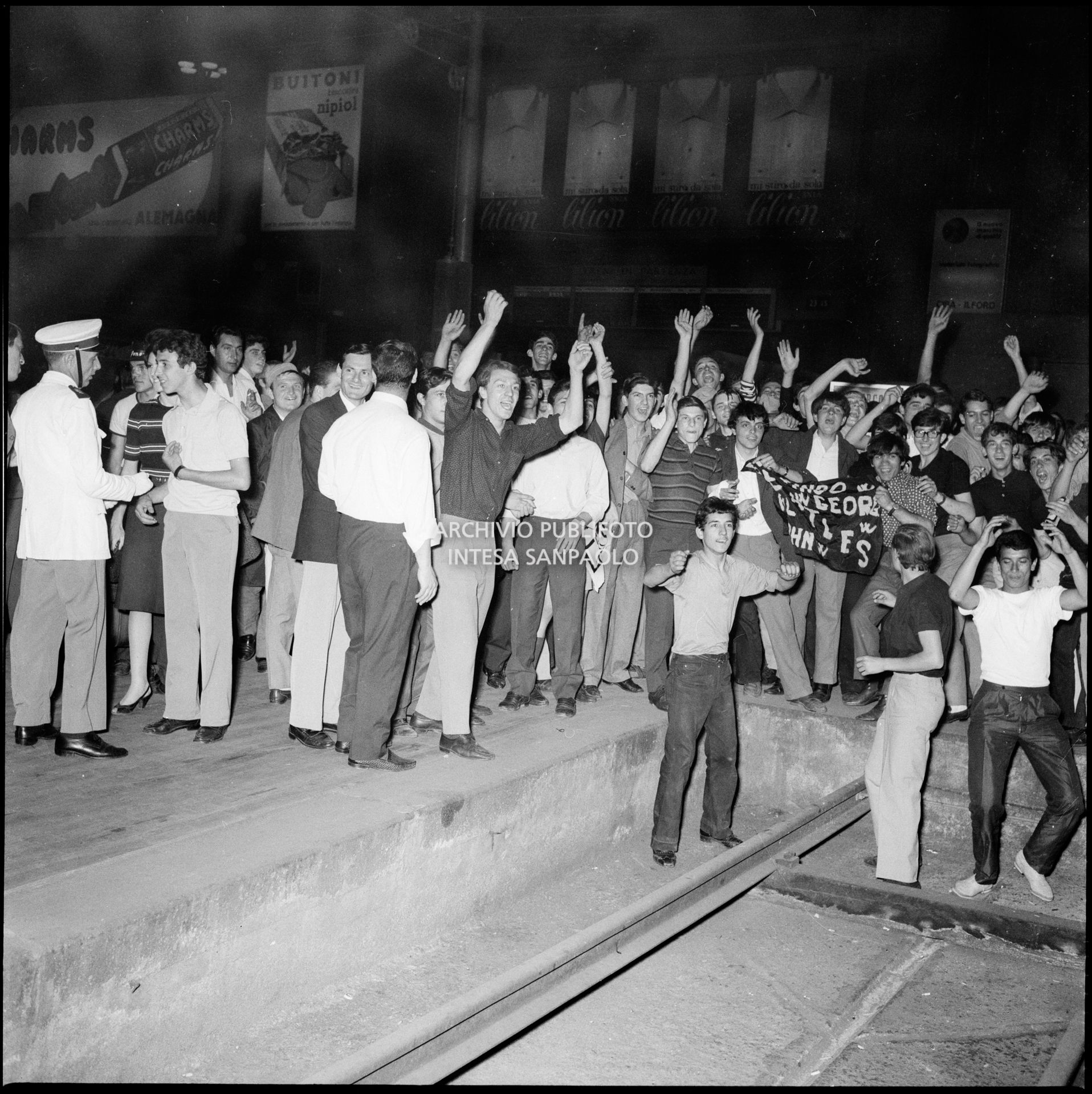 Fan dei Beatles in attesa dell'arrivo della band inglese ai binari della Stazione Centrale di Milano