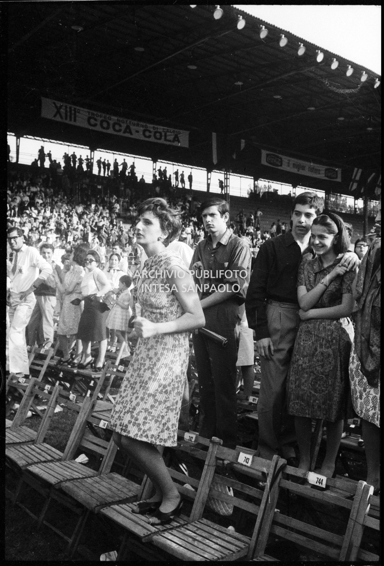 Pubblico in piedi sulle sedie al concerto pomeridiano dei Beatles al Vigorelli di Milano: in primo piano una ragazza balla, 24 june 1965, Cossu, Sergio, Pavone, Eugenio, Publifoto