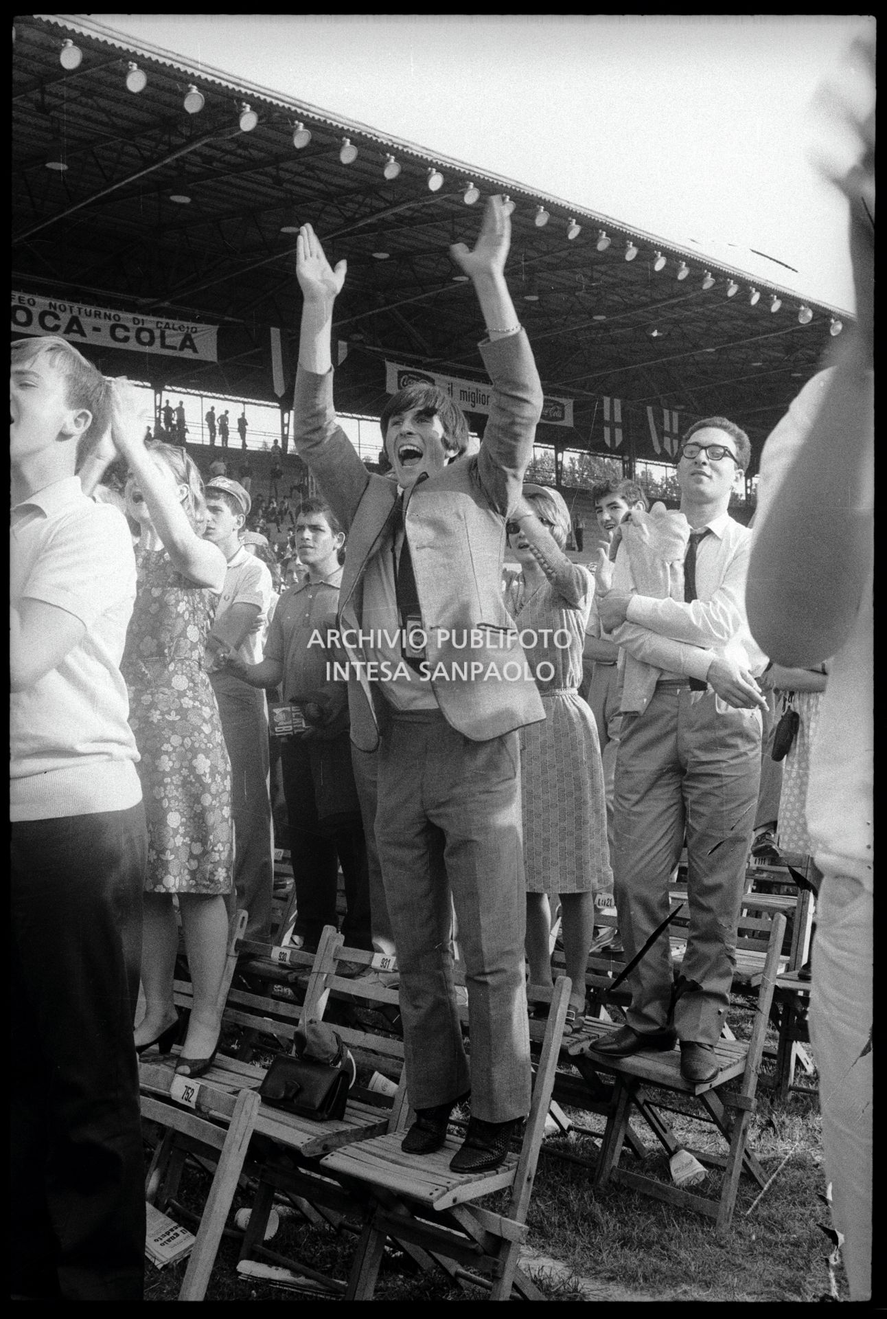 Un ragazzo entusiasta tra il pubblico in piedi sulle sedie al concerto pomeridiano dei Beatles al Vigorelli di Milano, 24 june 1965, Cossu, Sergio, Pavone, Eugenio, Publifoto