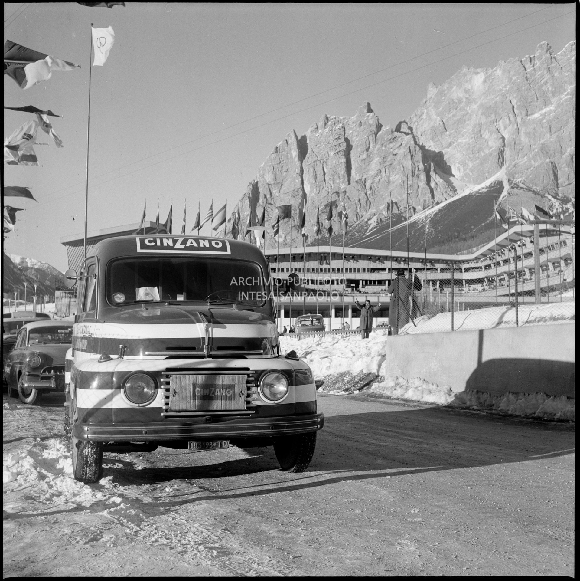 Autocarro Fiat 615 che pubblicizza il Cinzano a Cortina d'Ampezzo nei giorni dei VII Giochi olimpici invernali; sullo sfondo lo Stadio del ghiaccio