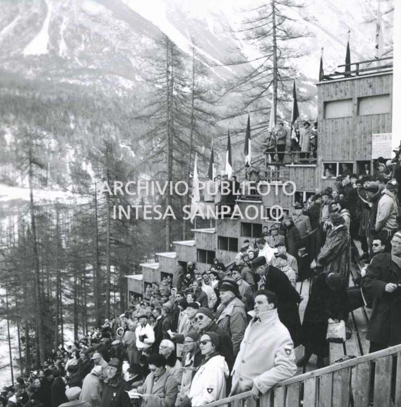 Spettatori assistono a una gara di salto con gli sci al Trampolino Italia durante i VII Giochi olimpici invernali a Cortina d'Ampezzo