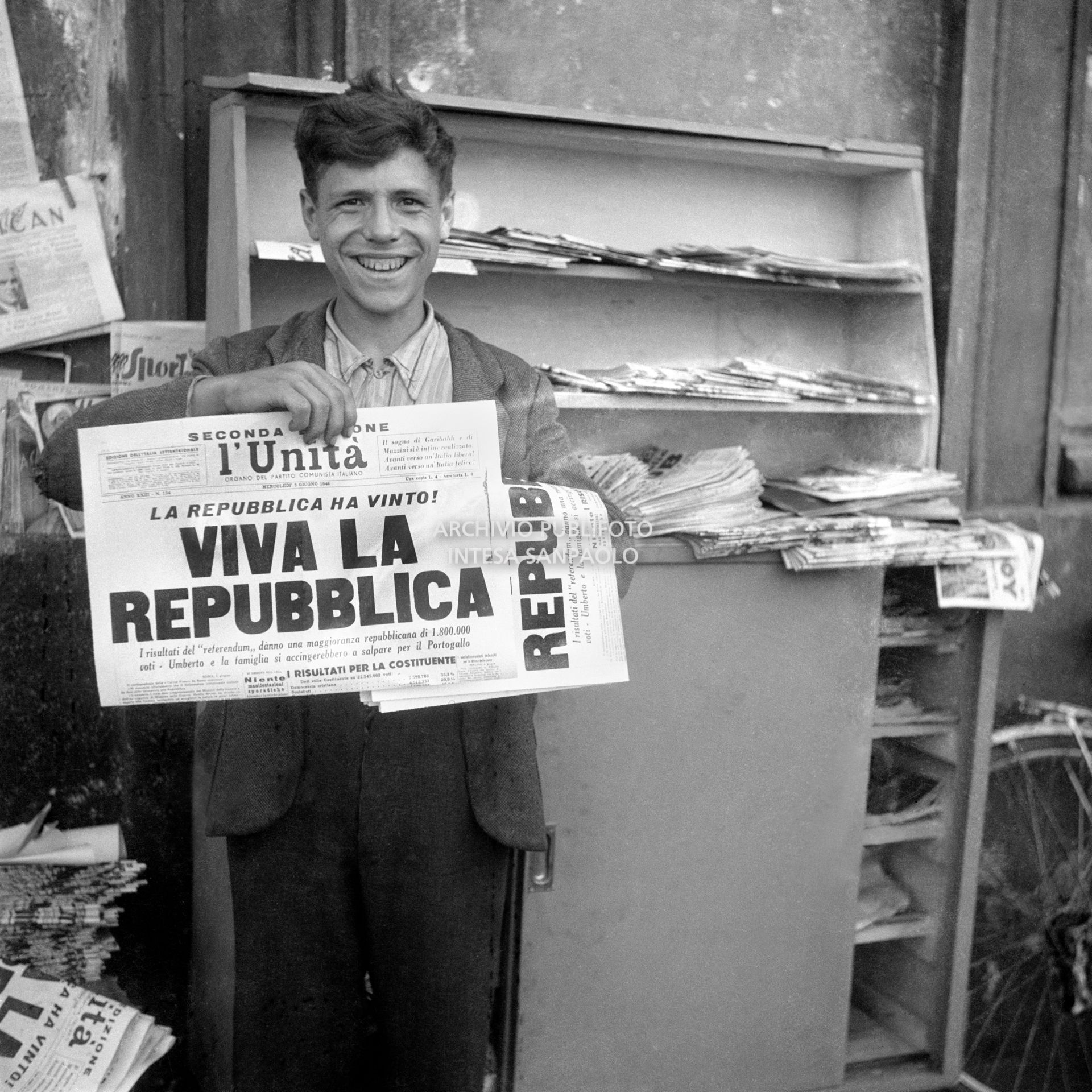 A boy shows the front page of l'Unità newspaper following the institutional referendum to replace the monarchy with a republic