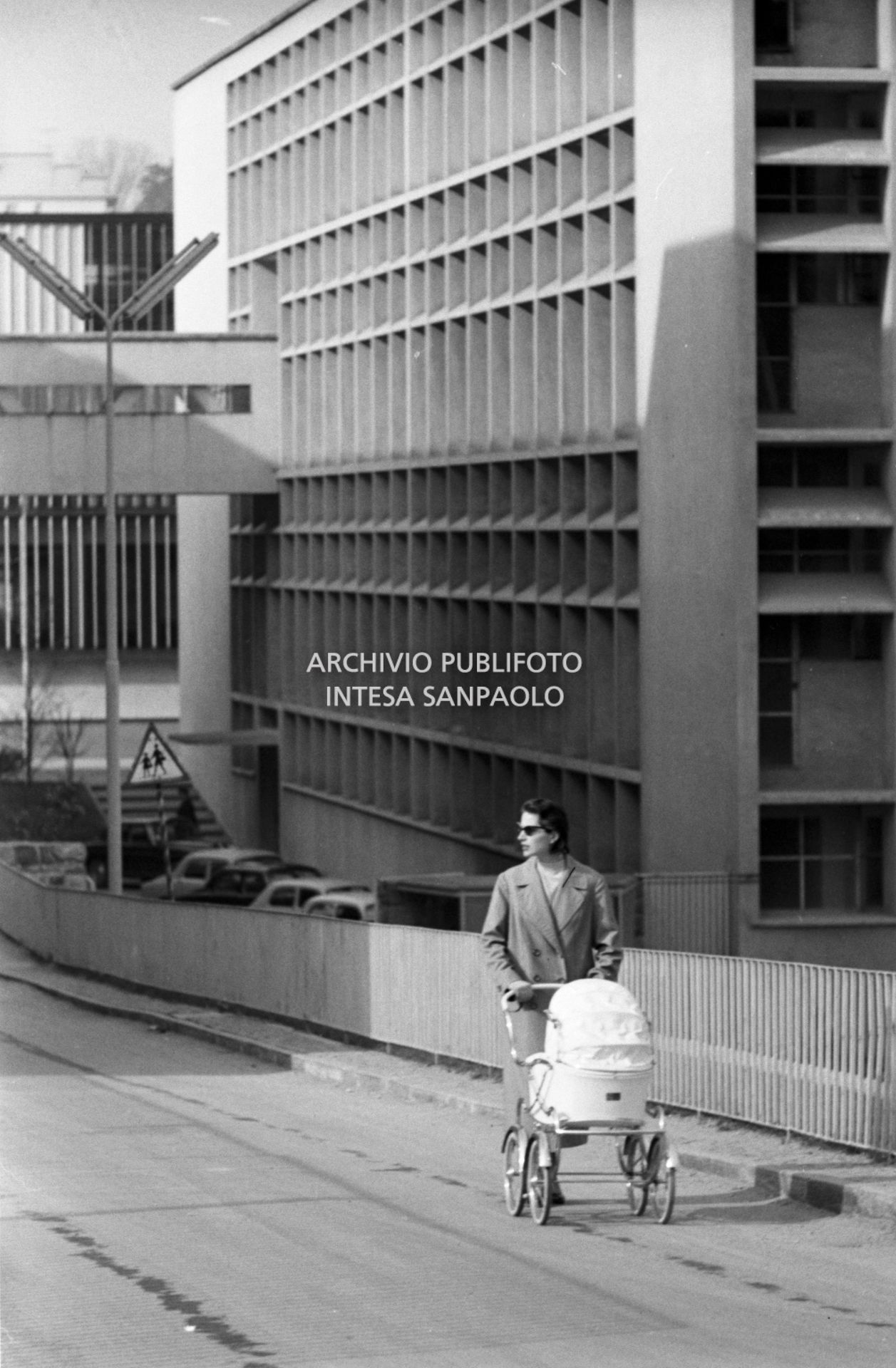 Una donna spinge una carrozzina tra gli edifici industriali della Olivetti, 17 march 1958, Novi, Angelo, Publifoto