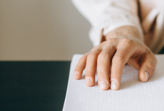 Immagine di una mano che legge in braille