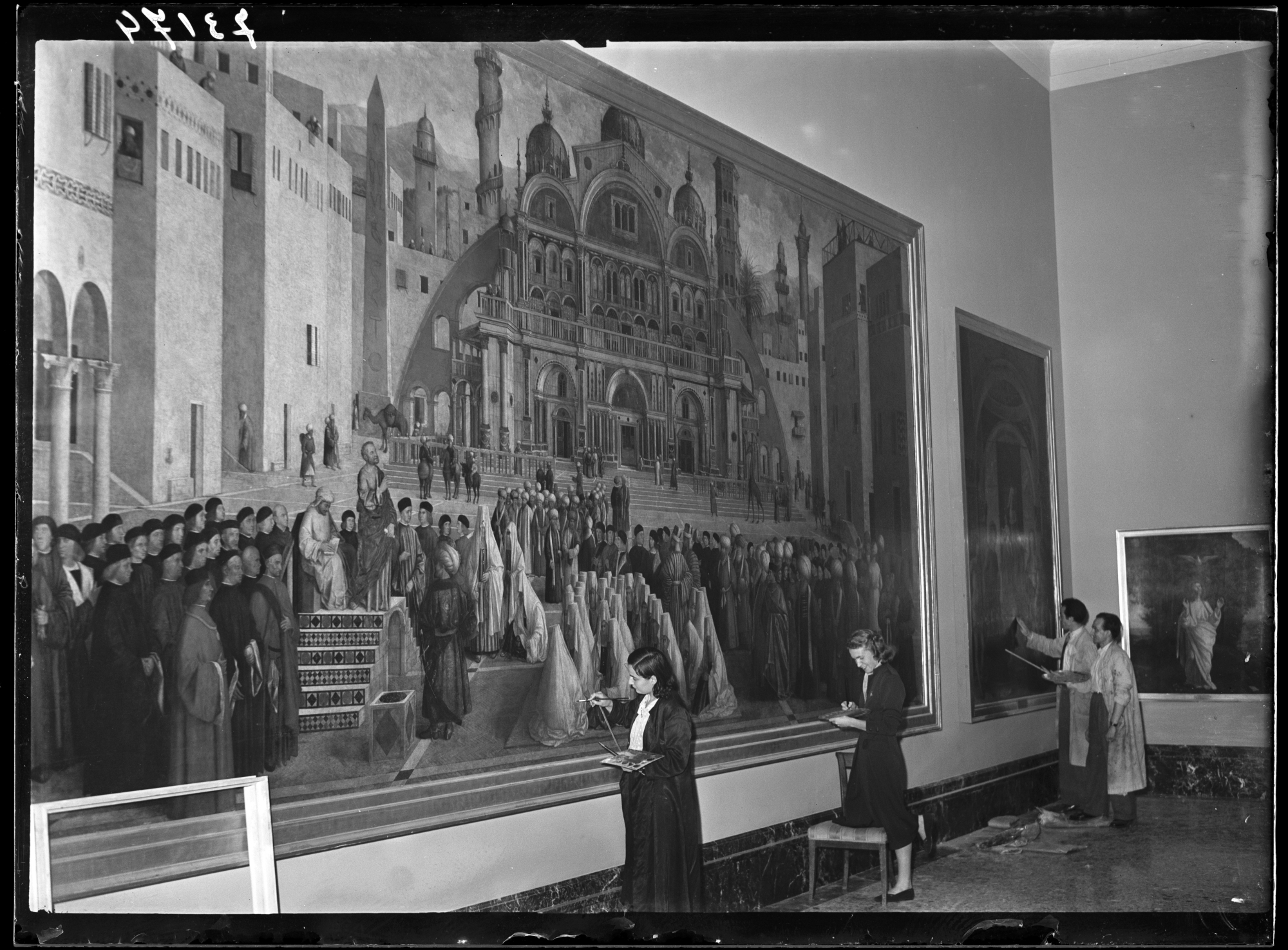 Restorers at work on the painting by Gentile Bellini and Giovanni Bellini "Predica di San Marco in una piazza di Alessandria d’Egitto", for the reopening of the Brera Art Gallery after the war, 1 June 1950